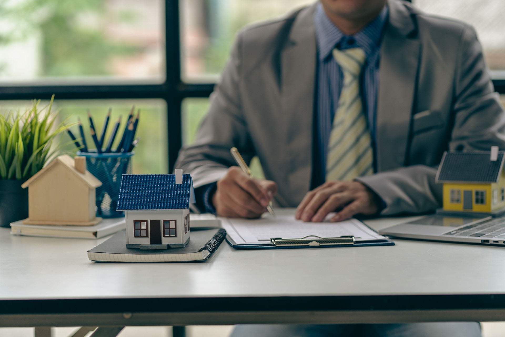 Businessman signs agreement, contract, signing, contract document being signed by the customer as evidence to the real estate agent or bank officer according to the mortgage guarantee agreement